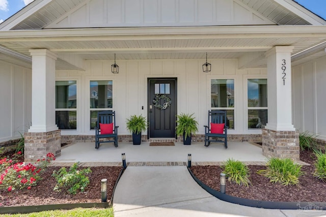 entrance to property featuring board and batten siding and covered porch