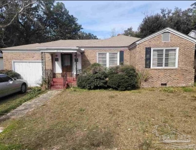 single story home featuring crawl space, an attached garage, a front lawn, and brick siding