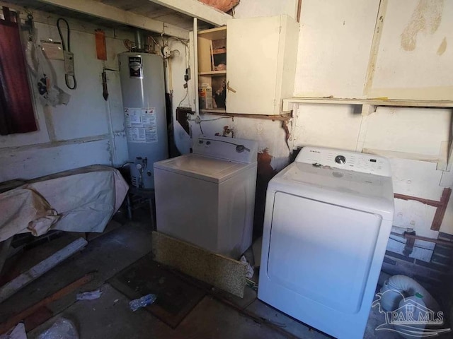 clothes washing area featuring gas water heater, washing machine and dryer, and laundry area