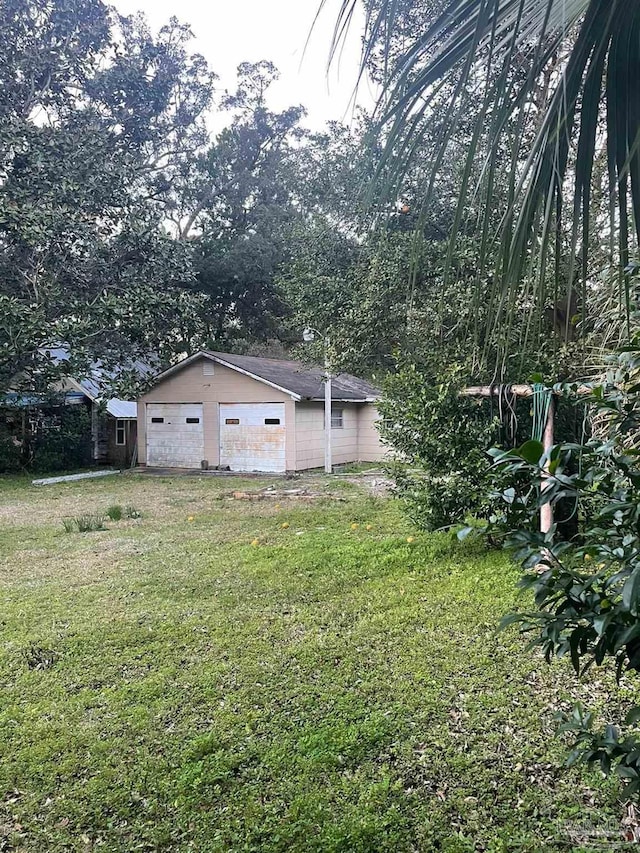 view of yard featuring a detached garage and an outbuilding