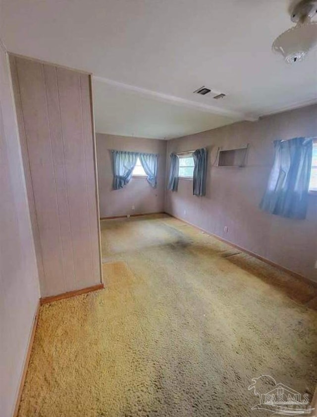 unfurnished room with visible vents, baseboards, and carpet floors