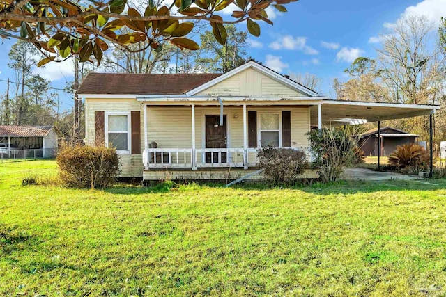 view of front facade featuring covered porch, a front lawn, and a carport