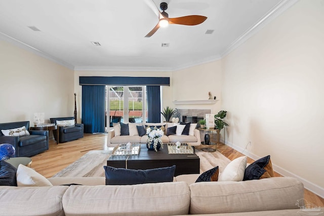 living room with light hardwood / wood-style floors, ornamental molding, and ceiling fan