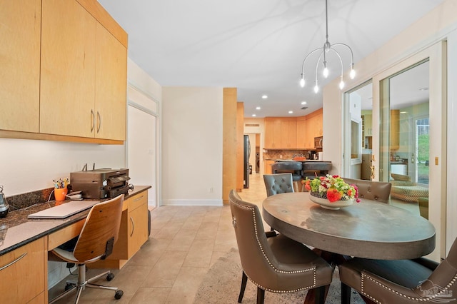 dining room with built in desk, light tile patterned flooring, and a chandelier