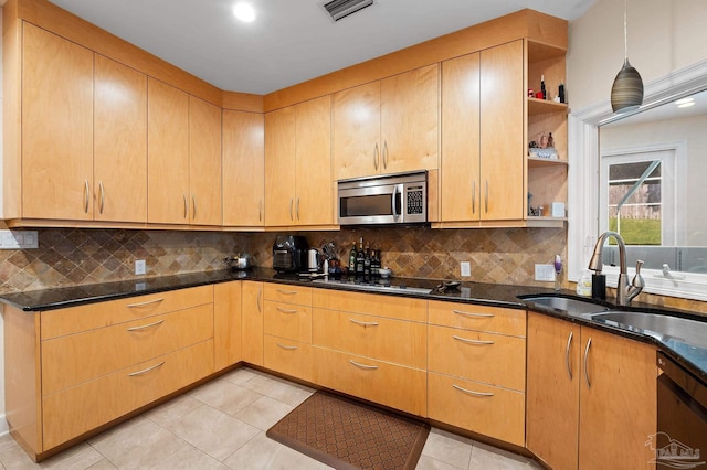 kitchen featuring stainless steel appliances, backsplash, dark stone countertops, and sink