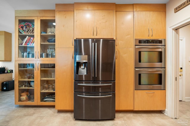 kitchen featuring light brown cabinetry, stainless steel appliances, and light tile patterned floors