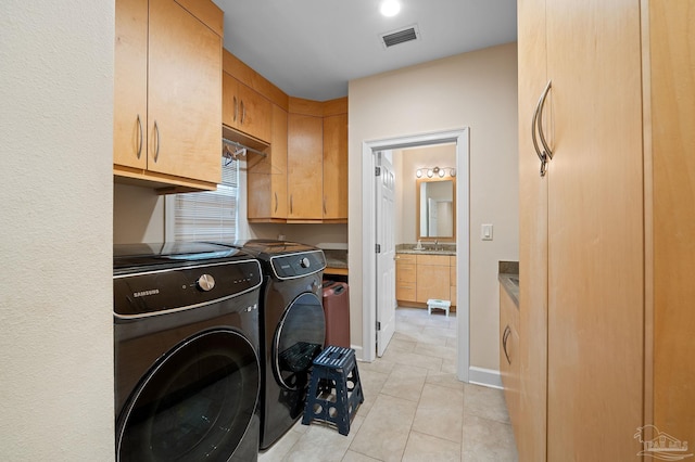 laundry area featuring cabinets, sink, washer and dryer, and light tile patterned flooring