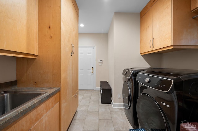 laundry area featuring light tile patterned flooring, washer and dryer, and cabinets