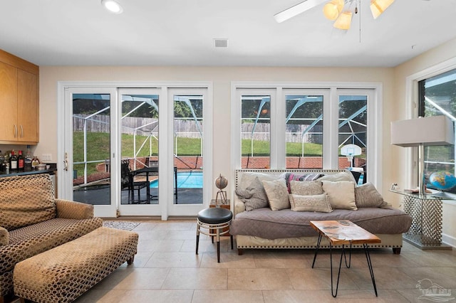 living room with ceiling fan, light tile patterned floors, and a wealth of natural light