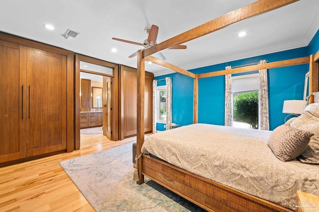 bedroom featuring light wood-type flooring, connected bathroom, ornamental molding, and ceiling fan