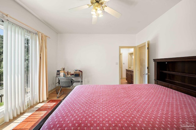 bedroom featuring ceiling fan, hardwood / wood-style floors, and multiple windows