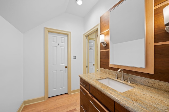 bathroom featuring vanity, vaulted ceiling, and hardwood / wood-style flooring