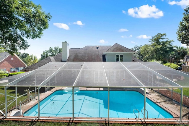 view of pool with glass enclosure