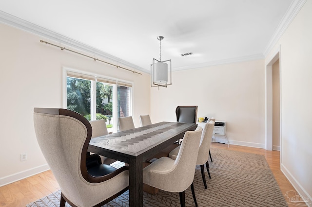 dining area with light hardwood / wood-style floors and ornamental molding