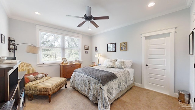 carpeted bedroom featuring crown molding and ceiling fan