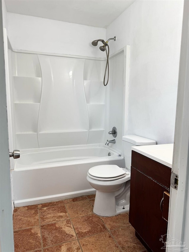 full bath featuring vanity, stone finish floor, toilet, and tub / shower combination