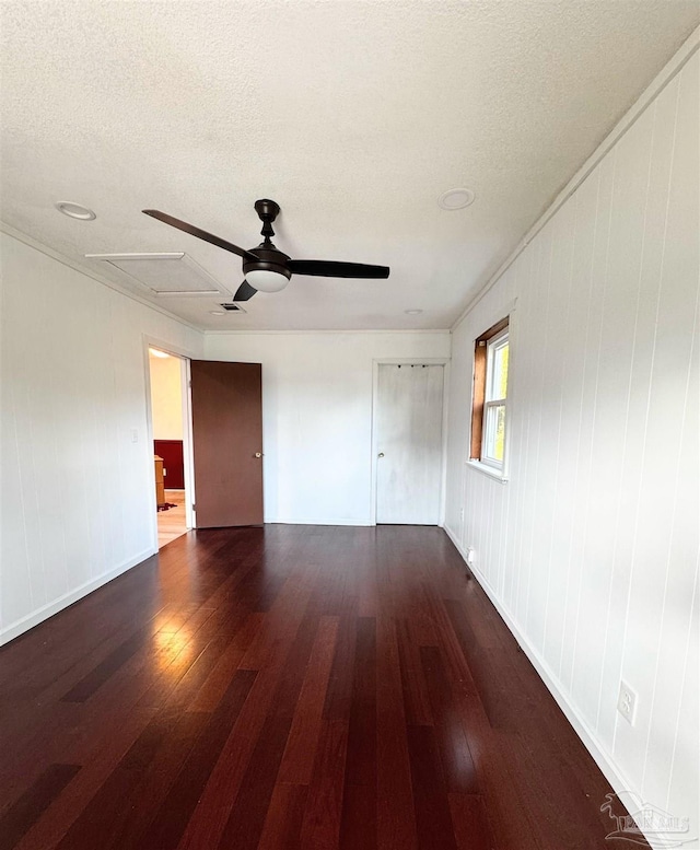 empty room featuring visible vents, wood-type flooring, a textured ceiling, and a ceiling fan