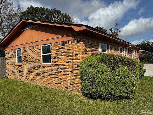 view of home's exterior featuring a yard and brick siding