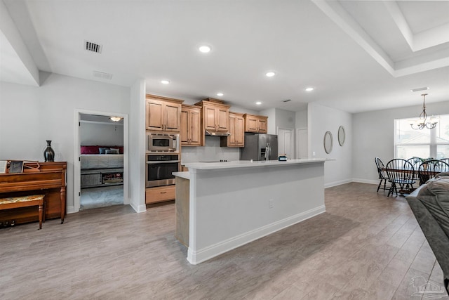 kitchen with a center island, light wood-type flooring, light brown cabinetry, appliances with stainless steel finishes, and a chandelier