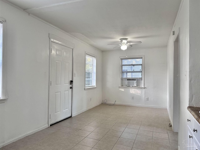 foyer entrance with crown molding, light tile patterned flooring, a ceiling fan, and baseboards