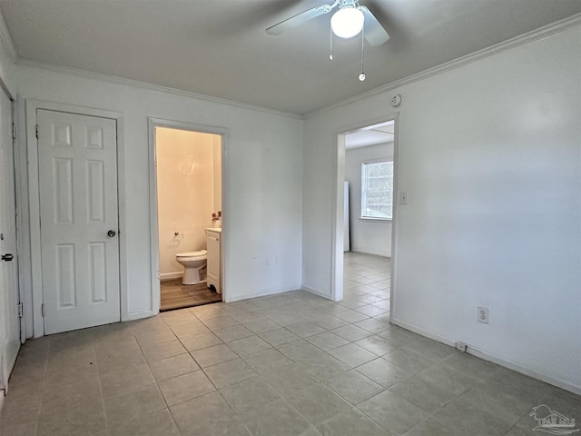 unfurnished bedroom with light tile patterned floors, baseboards, ceiling fan, ornamental molding, and ensuite bathroom