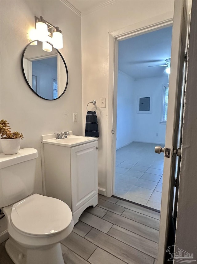 bathroom featuring toilet, ceiling fan, ornamental molding, and vanity