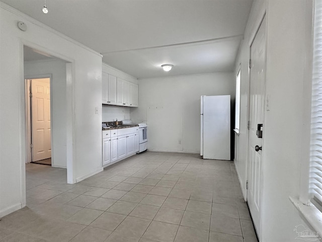 kitchen featuring white appliances, light tile patterned floors, baseboards, white cabinets, and ornamental molding