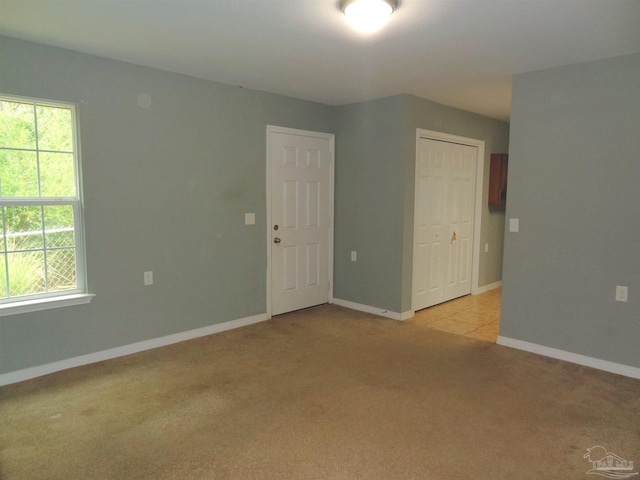 empty room featuring light carpet and plenty of natural light