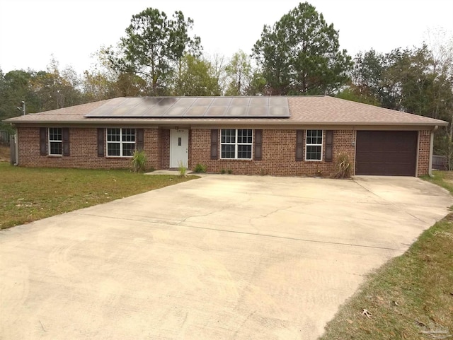 single story home featuring a front yard, a garage, and solar panels