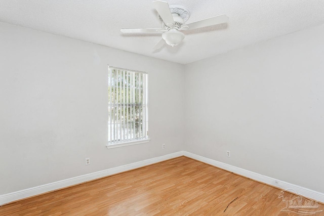 empty room with a textured ceiling, ceiling fan, and light hardwood / wood-style flooring