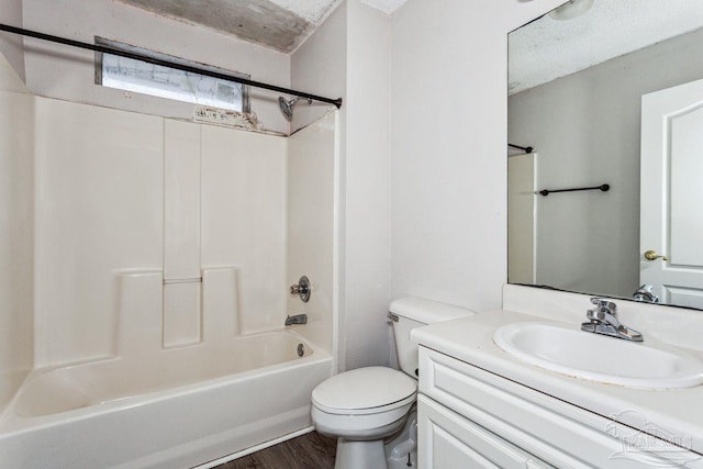 full bathroom featuring shower / bathtub combination, wood-type flooring, vanity, toilet, and a textured ceiling