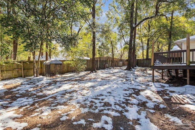 yard layered in snow featuring a wooden deck