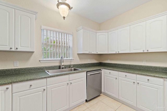 kitchen featuring stainless steel dishwasher, light tile patterned floors, sink, and white cabinets