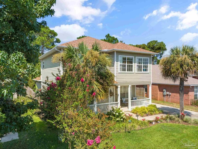 view of front of house featuring covered porch and a front lawn