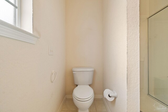 bathroom with tile patterned flooring, toilet, and walk in shower