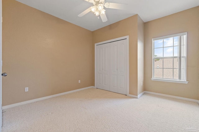 unfurnished bedroom with light carpet, a closet, and ceiling fan