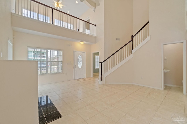 tiled foyer featuring a towering ceiling