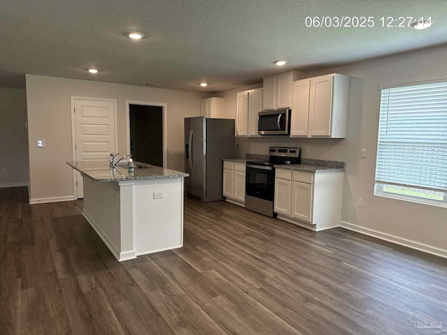 8659 Tarsus Dr, Milton, FL 32583 - kitchen with stainless steel appliances, a textured ceiling, dark wood-type flooring, white cabinetry, and recessed lighting