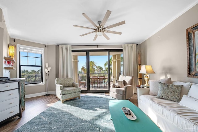 living room featuring wood finished floors, baseboards, plenty of natural light, and ornamental molding