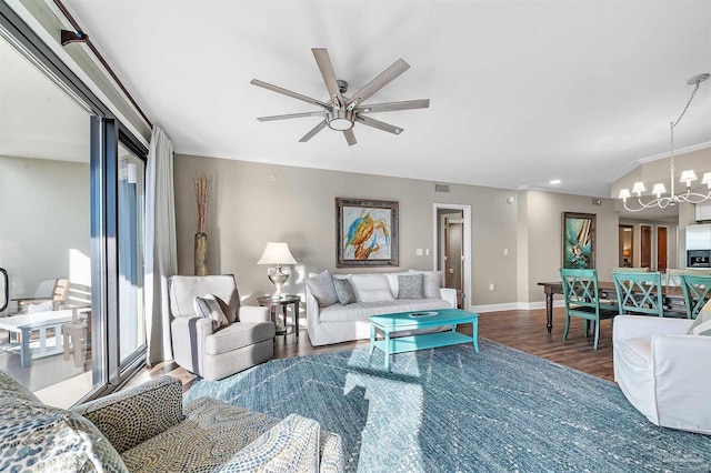 living room featuring visible vents, ceiling fan with notable chandelier, baseboards, and wood finished floors