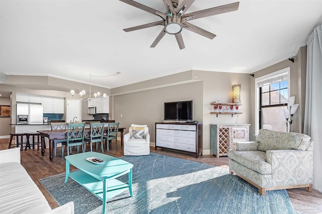 living room with ceiling fan with notable chandelier, crown molding, wood finished floors, and baseboards