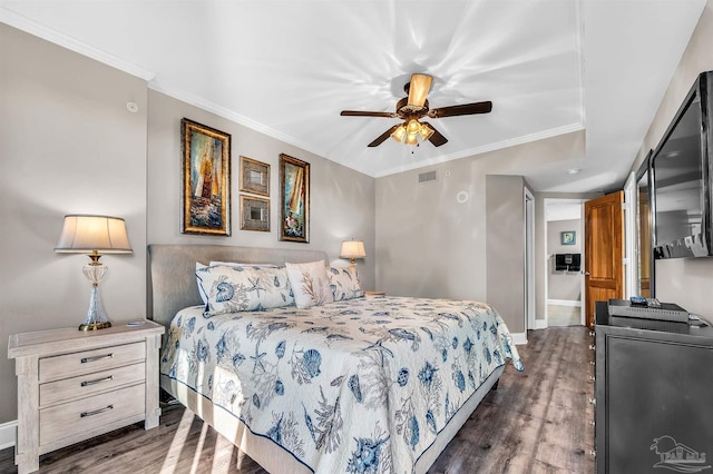 bedroom featuring a ceiling fan, baseboards, visible vents, dark wood finished floors, and crown molding