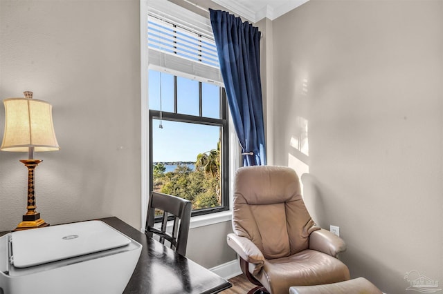 office featuring ornamental molding, a high ceiling, baseboards, and wood finished floors