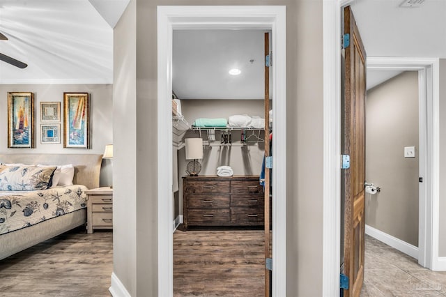 bedroom featuring visible vents, wood finished floors, a closet, baseboards, and a spacious closet