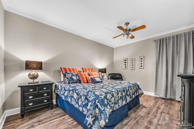 bedroom with baseboards, a ceiling fan, wood finished floors, and crown molding