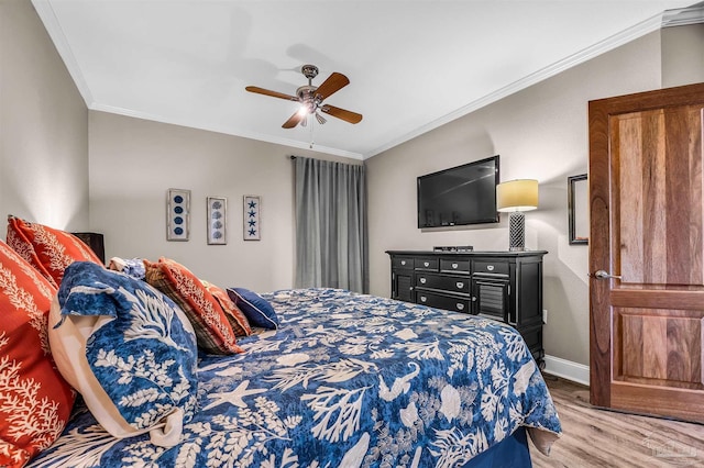 bedroom featuring baseboards, a ceiling fan, wood finished floors, and crown molding