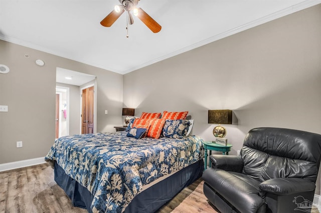 bedroom featuring ornamental molding, a ceiling fan, baseboards, and wood finished floors