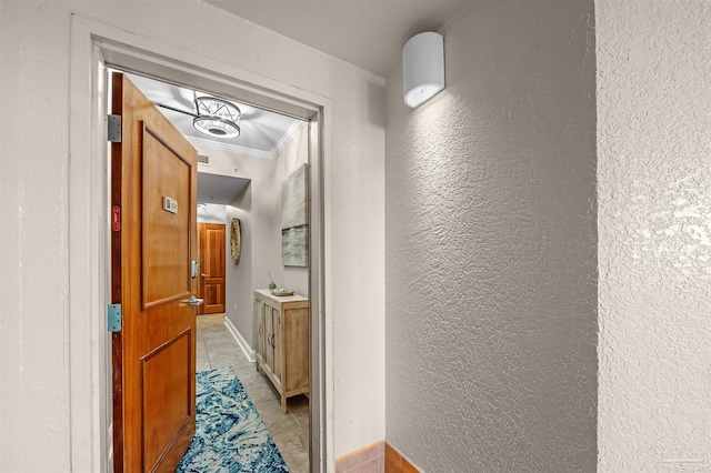 hallway featuring crown molding and a textured wall