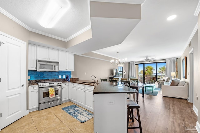 kitchen featuring a sink, a peninsula, crown molding, and stainless steel appliances