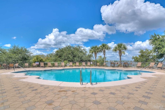 pool with a patio area and fence